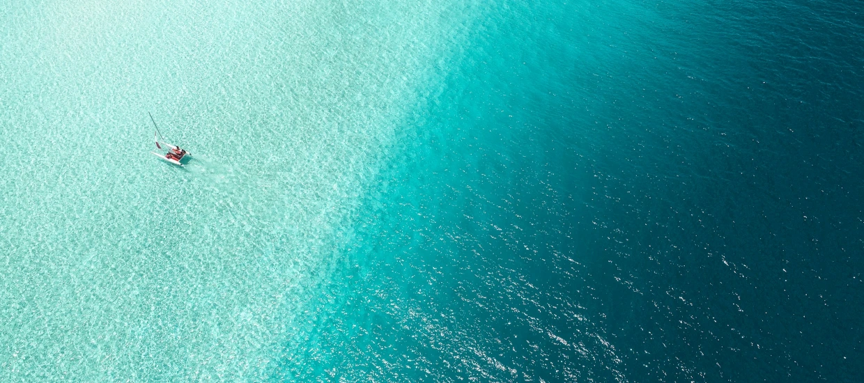 B2B Commitment from Fun & Sun: Overlay of a serene ocean view featuring a kayaker, accompanied by the quote emphasizing their dedication to empowering partners through innovative and reliable travel solutions, with a 